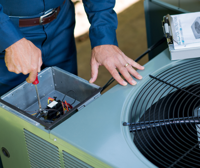 Technician servicing air conditioner